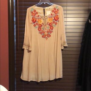 beige dress with embroidery on chest and sleeves